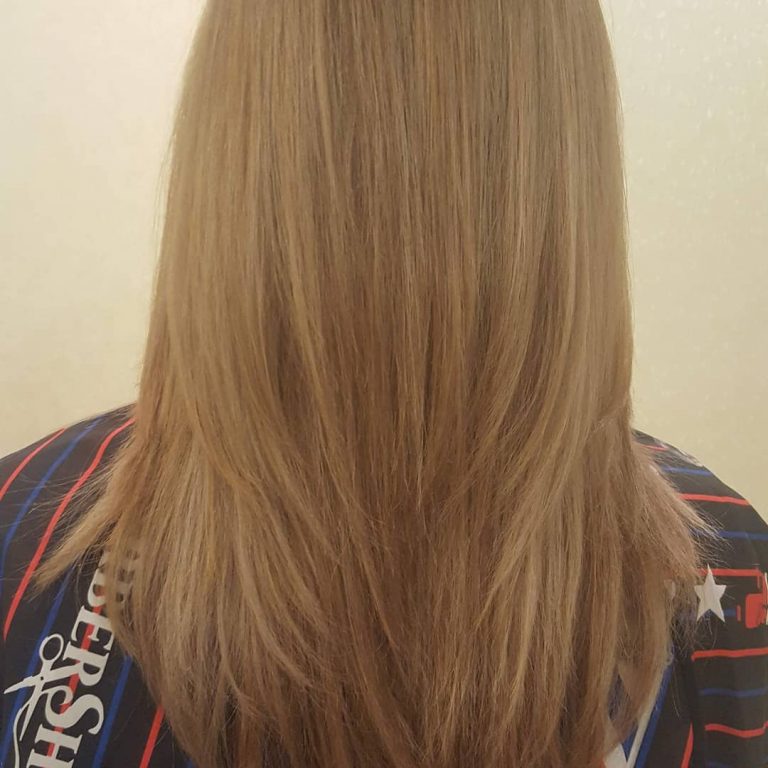 Damskie cieniowane strzyżenie i koloryzacja, długie włosy blond — widok z tyłu