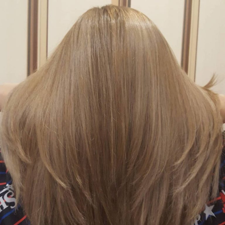 Strzyżenie cieniowane na długich włosach blond — widok z tyłu
