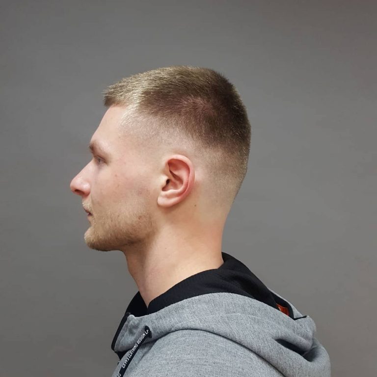 Short men's fade with light stubble — side profile