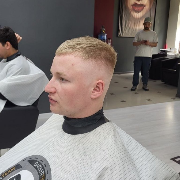 Jasne, krótkie strzyżenie z przejściem — profil, wnętrze barbershopu