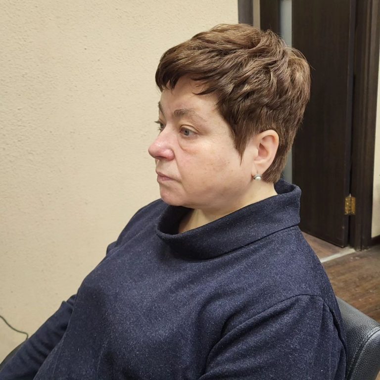 Damskie krótkie strzyżenie pixie z grzywką — profil, przy uchylonych drzwiach