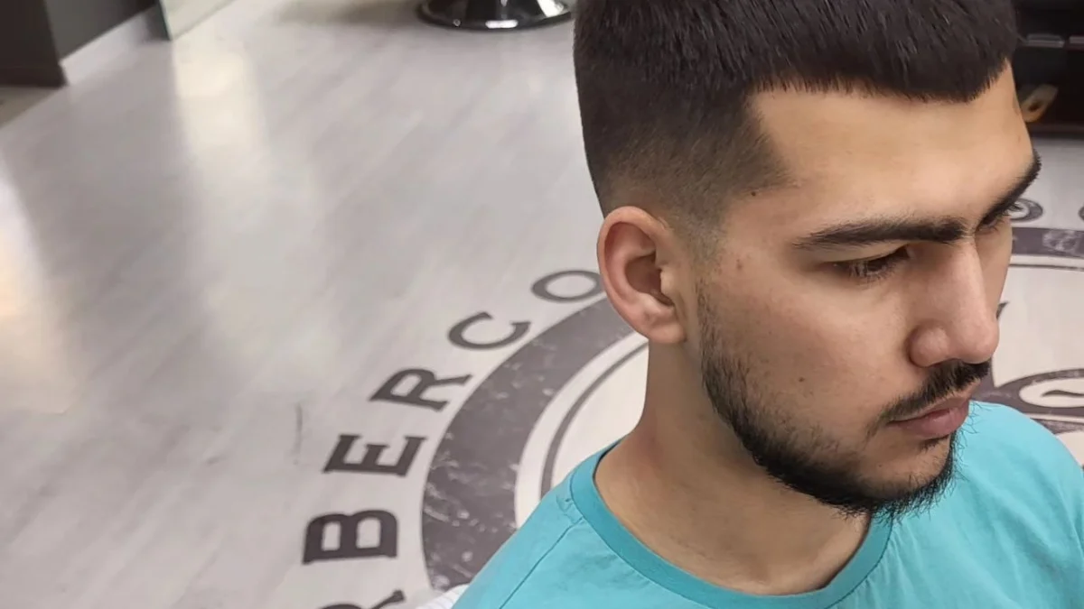 Krótkie strzyżenie z wyraźnym przejściem — profil, wnętrze barbershopu