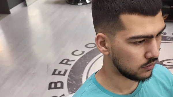 Krótkie strzyżenie z wyraźnym przejściem — profil, wnętrze barbershopu
