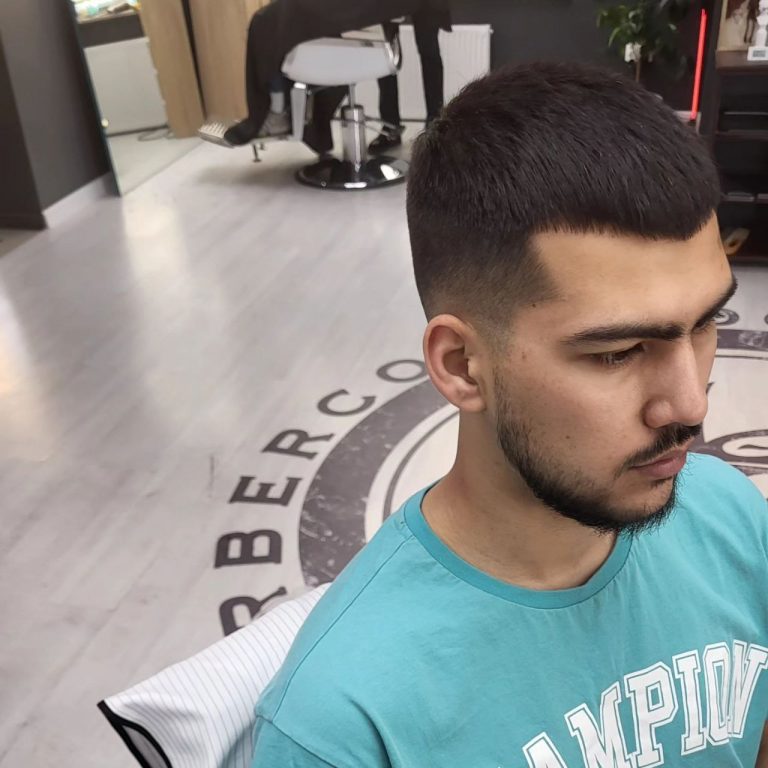 Krótkie strzyżenie z wyraźnym przejściem — profil, wnętrze barbershopu